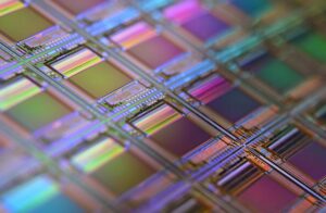 TSMC 실적발표 3분기 결과를 상징하는 무지갯빛 칩이 새겨진 반도체 실리콘 웨이퍼